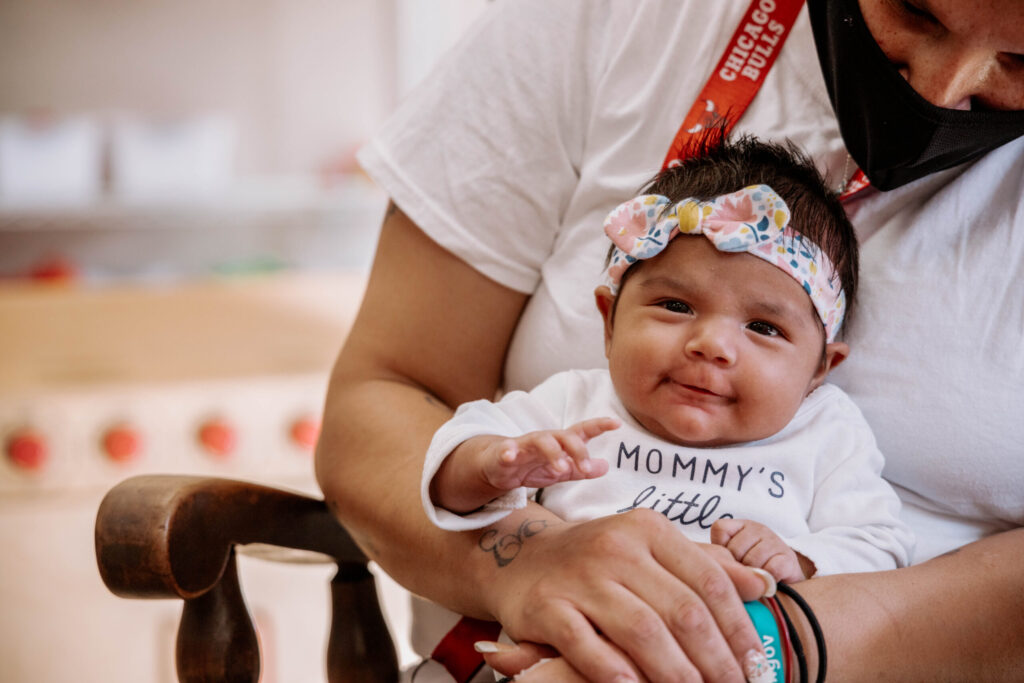 Lydia house volunteer holding a baby.