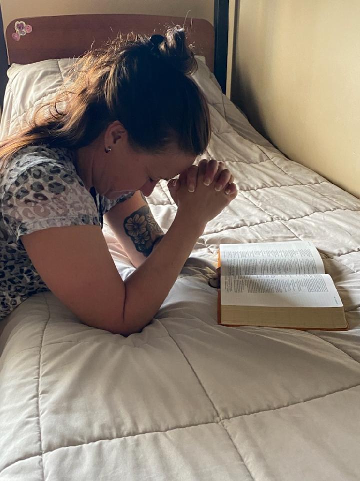 A woman praying, seeking solace and guidance.