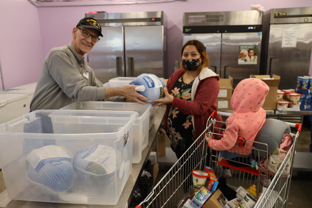 A guest receiving supplies from a volunteer.