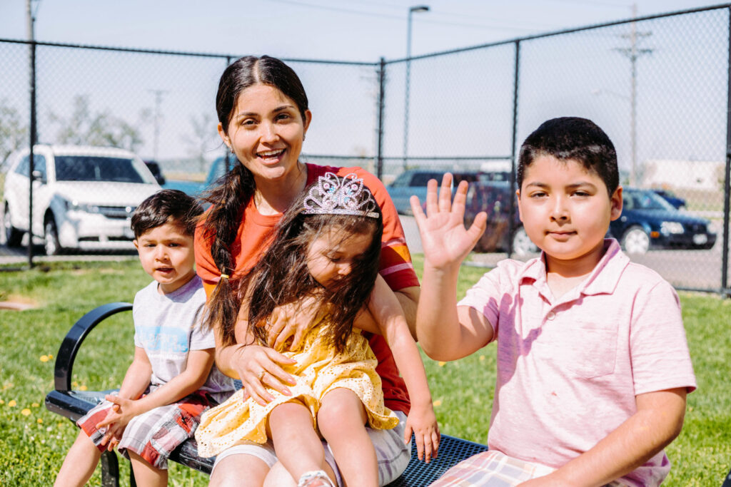 A photo of a woman (Helen) and her kids in a park setting