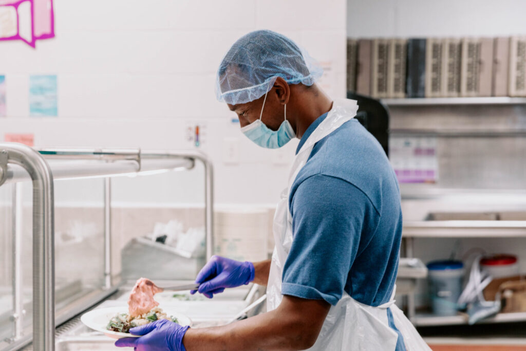 volunteer helping prep food at the mission