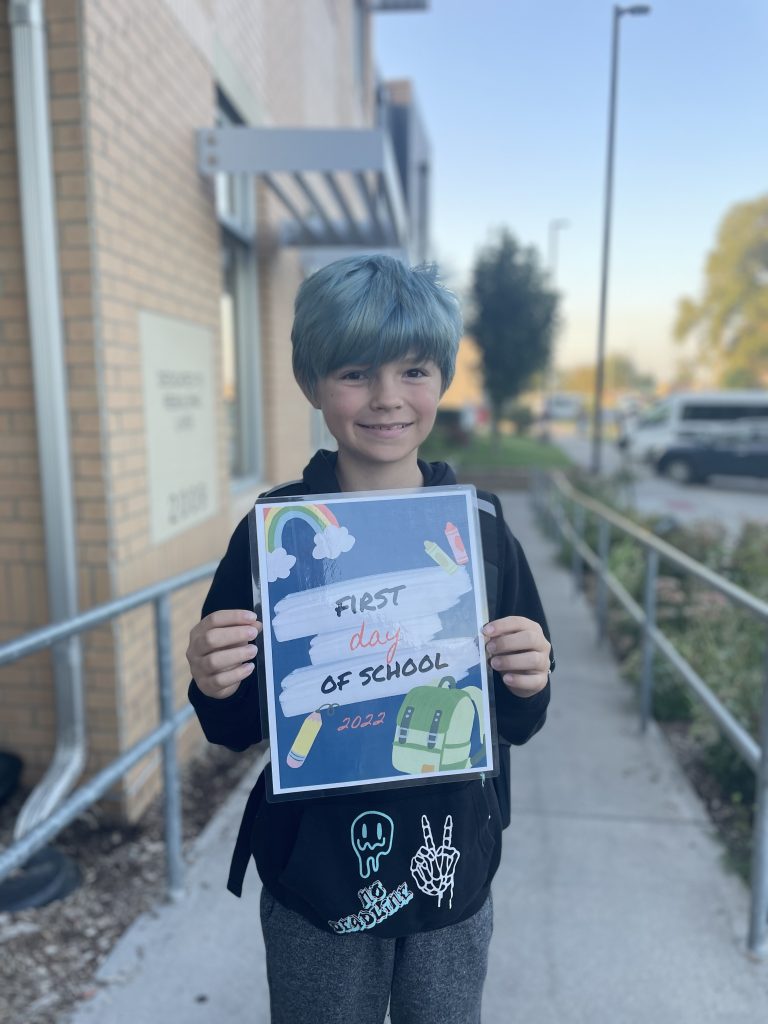 student hold a first day of school sign