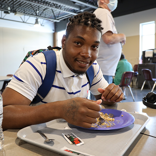 A person eating a meal at the mission.